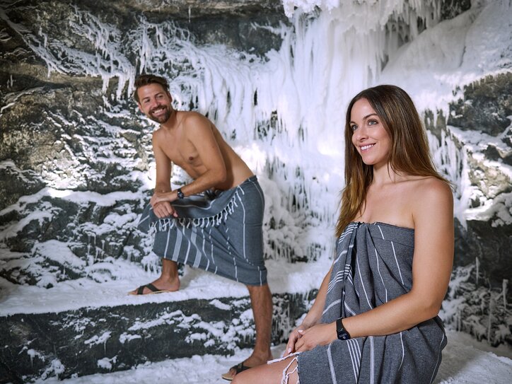 Two people in the snow grotto with towels