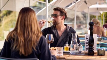 Zwei Personen beim Essen im Außenbereich des Restaurants, entspannte Stimmung bei Speisen und Getränken
